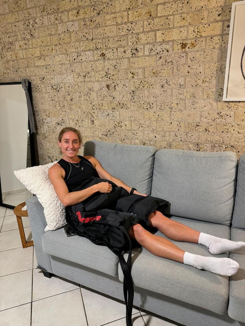 A woman is on the couch wearing recovery short for hips and glutes product