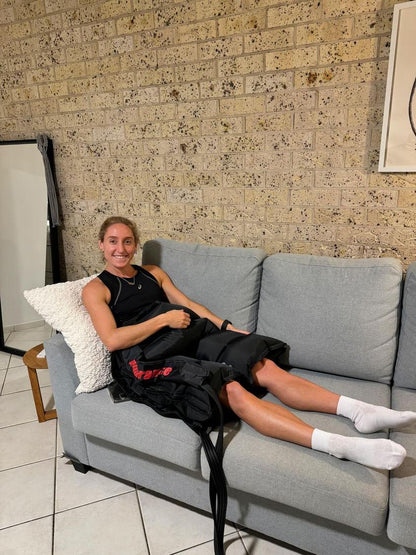 A woman is on the couch wearing recovery short for hips and glutes product